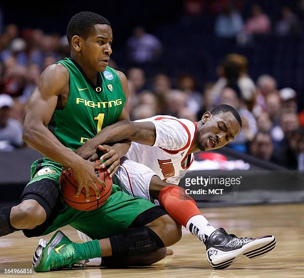 Oregon guard Dominic Artis and Louisville guard Russ Smith fight for this loose ball in second half action in their NCAA fourth round game on Friday,...