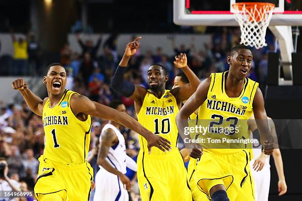 Glenn Robinson III, Tim Hardaway Jr. #10 and Caris LeVert of the Michigan Wolverines celebrate their 87 to 85 win over the Kansas Jayhawks in...