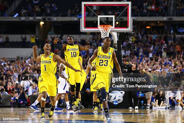 Glenn Robinson III, Tim Hardaway Jr. #10 and Caris LeVert of the Michigan Wolverines celebrate their 87 to 85 win over the Kansas Jayhawks in...