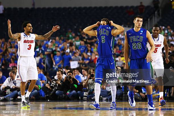 Mike Rosario of the Florida Gators celebrates as Christophe Varidel and Chase Fieler of the Florida Gulf Coast Eagles react to their 50 to 63 loss...