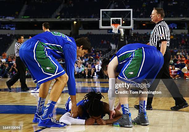 Sherwood Brown of the Florida Gulf Coast Eagles is helped to his feet by teammates during the second half against the Florida Gators during the South...