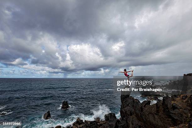 A Woman Doing Yoga On A Cliff By The Ocean, Foto de stock