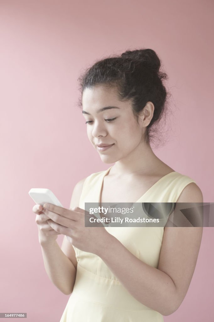 Girl in pastel yellow dress using smart phone