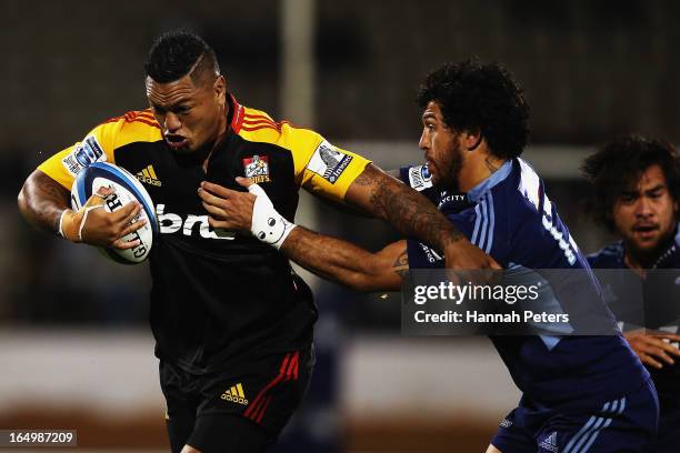 Hika Elliot of the Chiefs fends off Rene Ranger of the Blues during the round seven Super Rugby match between the Chiefs and the Blues at Bay Park on...