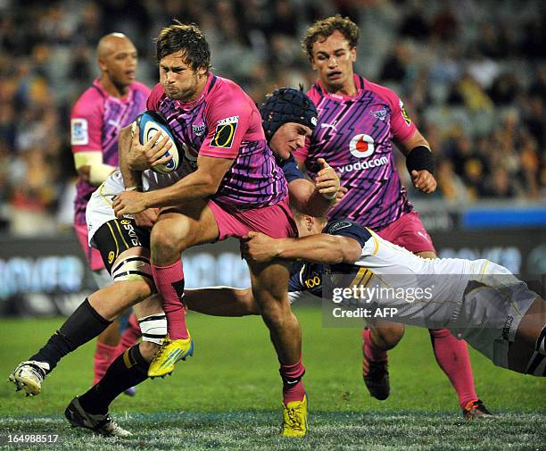 Jan Serfontein of the Bulls is tackled by Brumbies players during round 7 of the rugby Super 15 match in Canberra on March 30, 2013. AFP PHOTO / Mark...