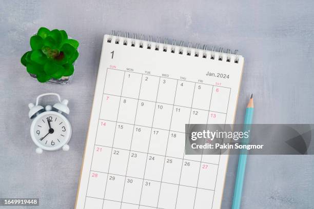 desk calendar 2024: january calendar is used to plan daily work and life, with an alarm clock and pencils on the work table. - date écrite photos et images de collection