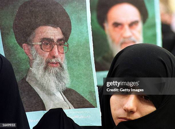 Student member of the Basij holds a picture of Iran's supreme leader, Ayatollah Ali Khamenei , next to a photo of Ayatollah Khomeini, founder of the...