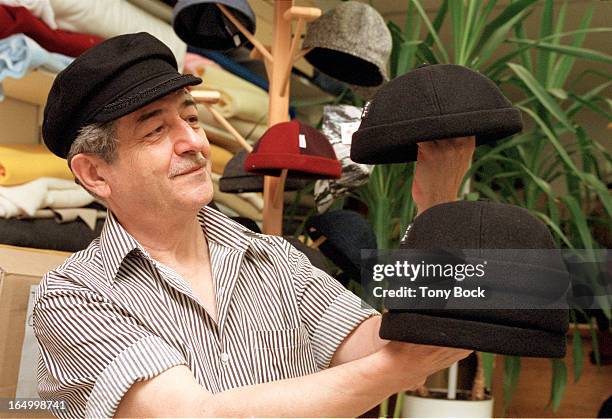 Hatmaker Louis Alexakos inspects one of the hats he has made for Big It Up. He is also wearing a Greek fisherman's hat as part of the order. Also at...