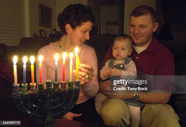 Allyson and Jason and 9-month-old Danielle Billings light a menorah in their Milton home. For Saturday GTA feature on how mixed-faith families are...