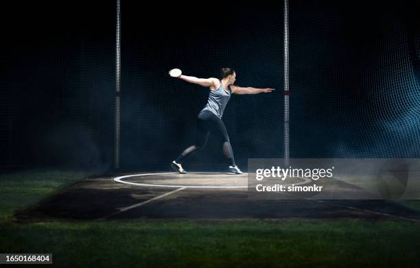 female athlete turning with discus - discus stock pictures, royalty-free photos & images