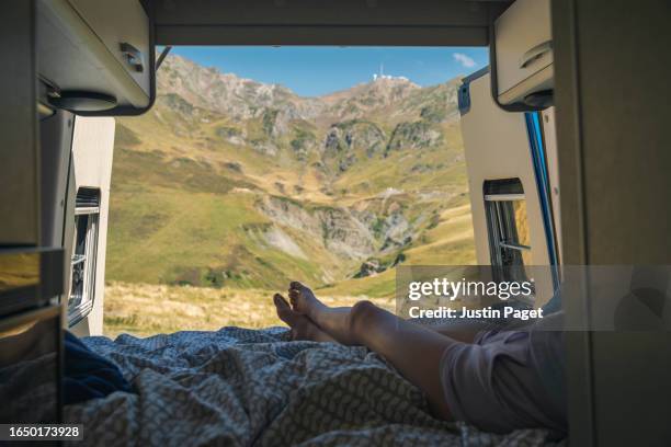 legs of an unrecognisable girl taking in the striking view of the pyrenees mountains from the back of her campervan - open day 13 stock pictures, royalty-free photos & images