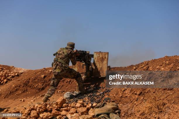 Fighter from the Turkish-supported forces mans a machine gun at the Buwayhij-Boughaz-Korhoyuk frontline on the outskirts of Manbij in northeastern...
