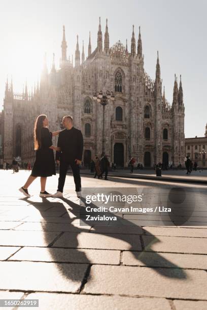romantic photo of lovers on the main square of milan, backlight - daily life at duomo square milan stockfoto's en -beelden