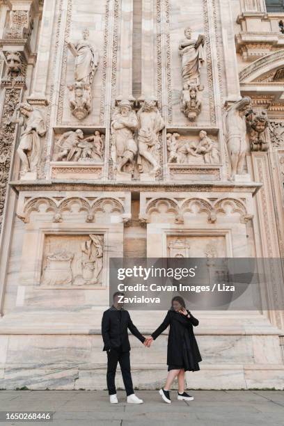 stylish couple in love walking on duomo square in italy - daily life at duomo square milan stockfoto's en -beelden