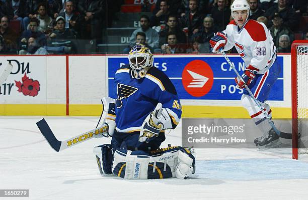 Fred Brathwaite of the St. Louis Blues makes a glove save while of Jan Bulis of the Montreal Canadiens looks on during the second period of the NHL...