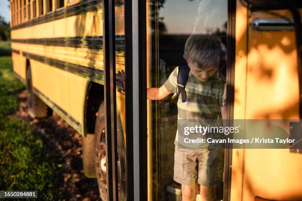 child getting off the bus at bus stop after school - step off bus stock pictures, royalty-free photos & images