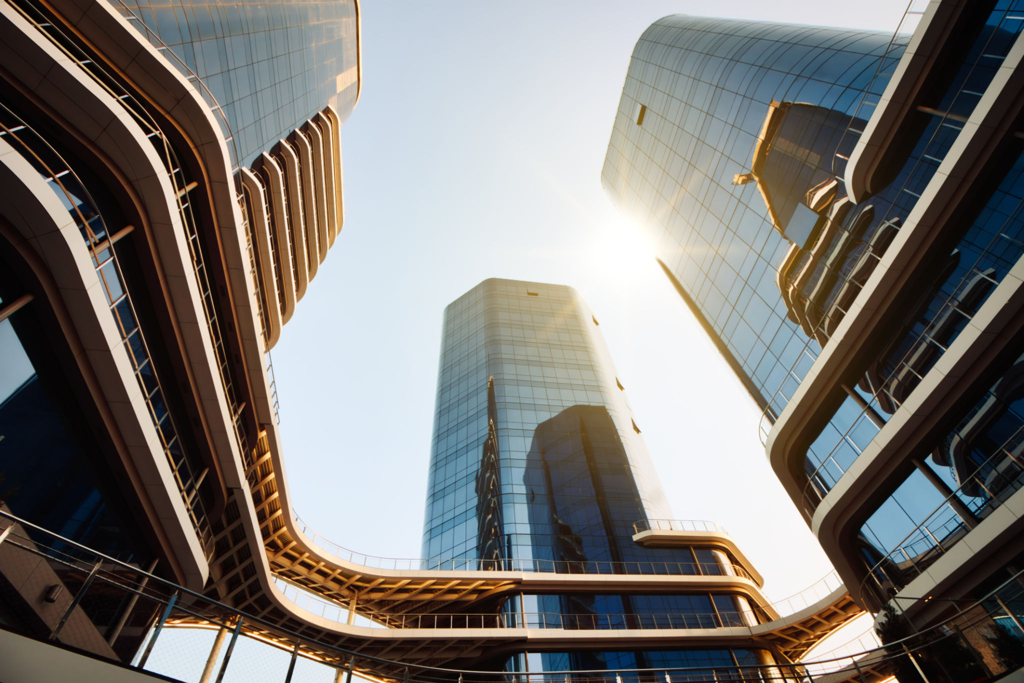 Cityscape view from below looking directly up at tall high-rise modern business buildings with glass facade Cityscape view from below looking directly up at tall high-rise modern business buildings with glass facade