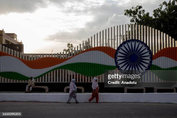 Women walk past in front of an installation with the colors of the national tricolor, ahead of the upcoming G20 Leadership Summit in New Delhi, India...