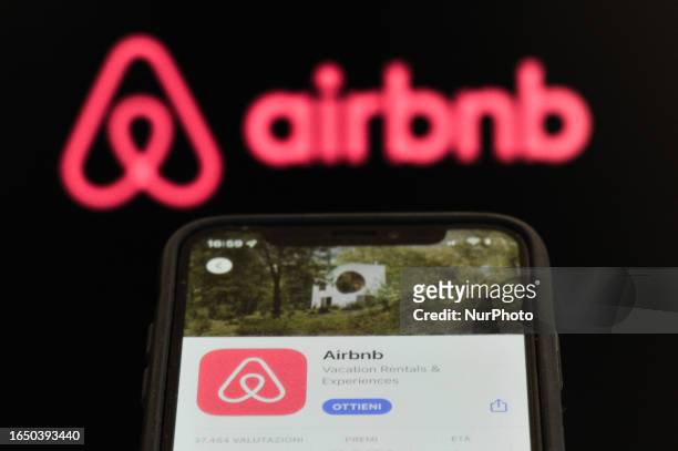 An Airbnb download app page displayed on a smartphone and an Airbnb logo displayed on a personal computer are seen in L'Aquila, Italy, on september...