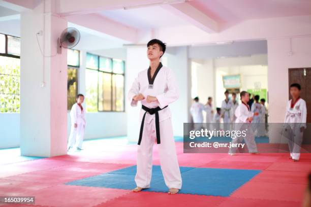 aisa man playing with taekwondo - taekwondo stock pictures, royalty-free photos & images