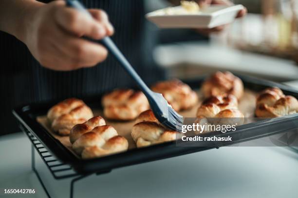 panadera untando pan con mantequilla - untar de mantequilla fotografías e imágenes de stock
