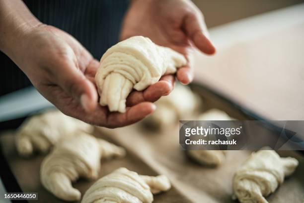 bäckerin, die croissant hält - geflochtenes brot stock-fotos und bilder