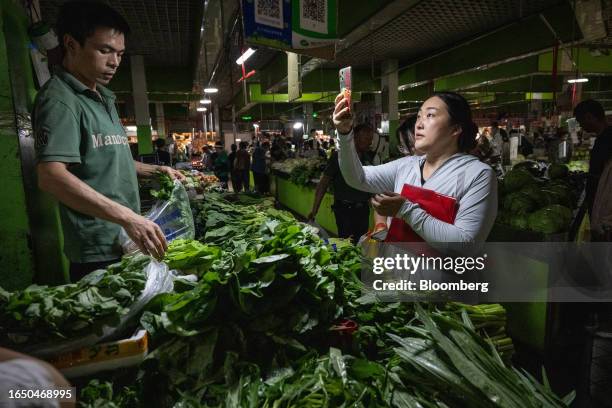 Customer scans a QR code to purchase vegetables at a wet market in Beijing, China, on Thursday, Sept. 7, 2023. China is scheduled to release consumer...