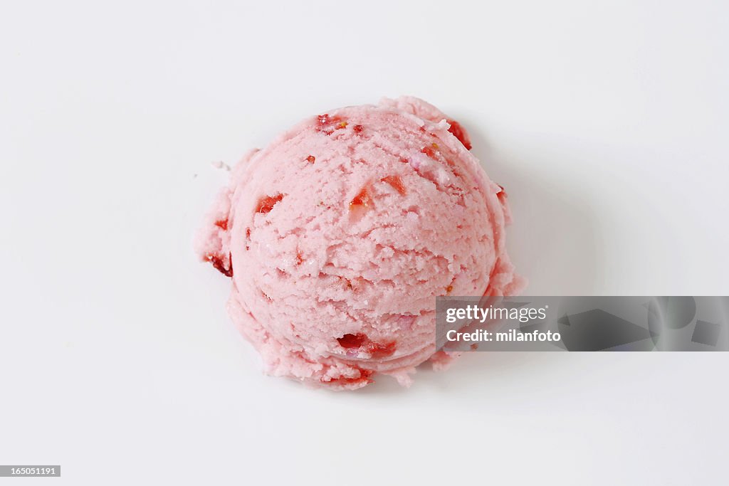 Single scoop of light pink strawberry ice cream on white