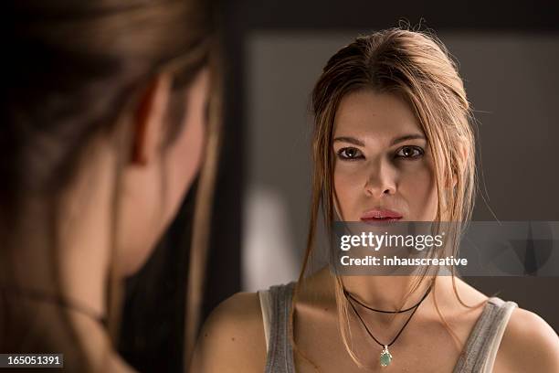 woman looking in mirror - face to face stock pictures, royalty-free photos & images