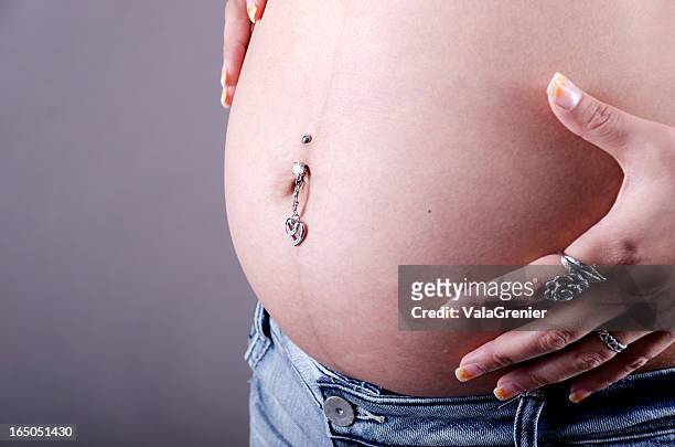 side view of pregnant belly with peircing. - body piercings stock pictures, royalty-free photos & images