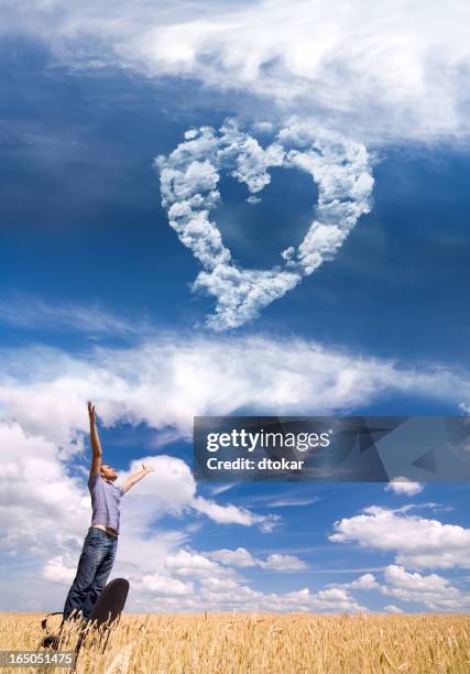 man in the field with heart cloudscape - skywriting stock pictures, royalty-free photos & images