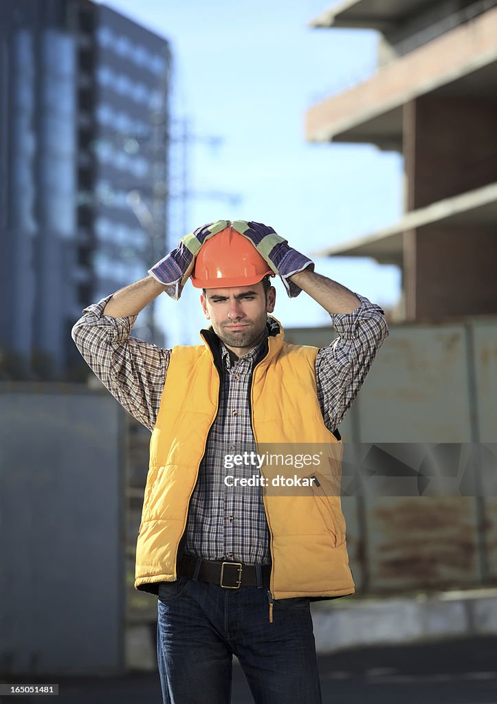 Disappointed builder or worker is thinking about problems.