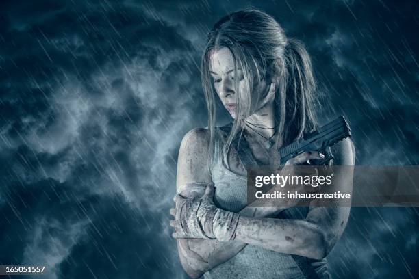 weiblichen models, die pistole in regen - heldin stock-fotos und bilder