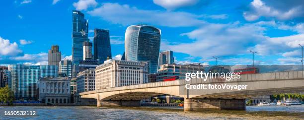 iconic red buses crossing london bridge towards city skyscrapers panorama - tower bridge imagens e fotografias de stock