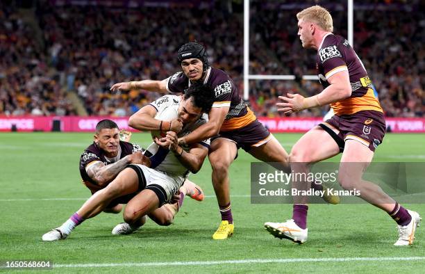 Reimis Smith of the Storm carries the defence with him to score a try during the round 27 NRL match between the Brisbane Broncos and Melbourne Storm...