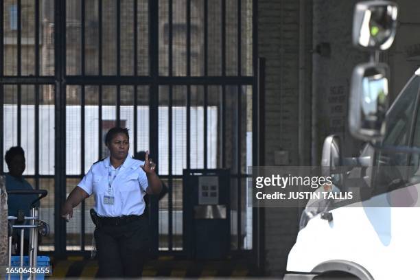 Prison guard gestures to the driver of a delivery van at the gates of HM Prison Wandsworth in south London on September 7 a day after terror suspect,...