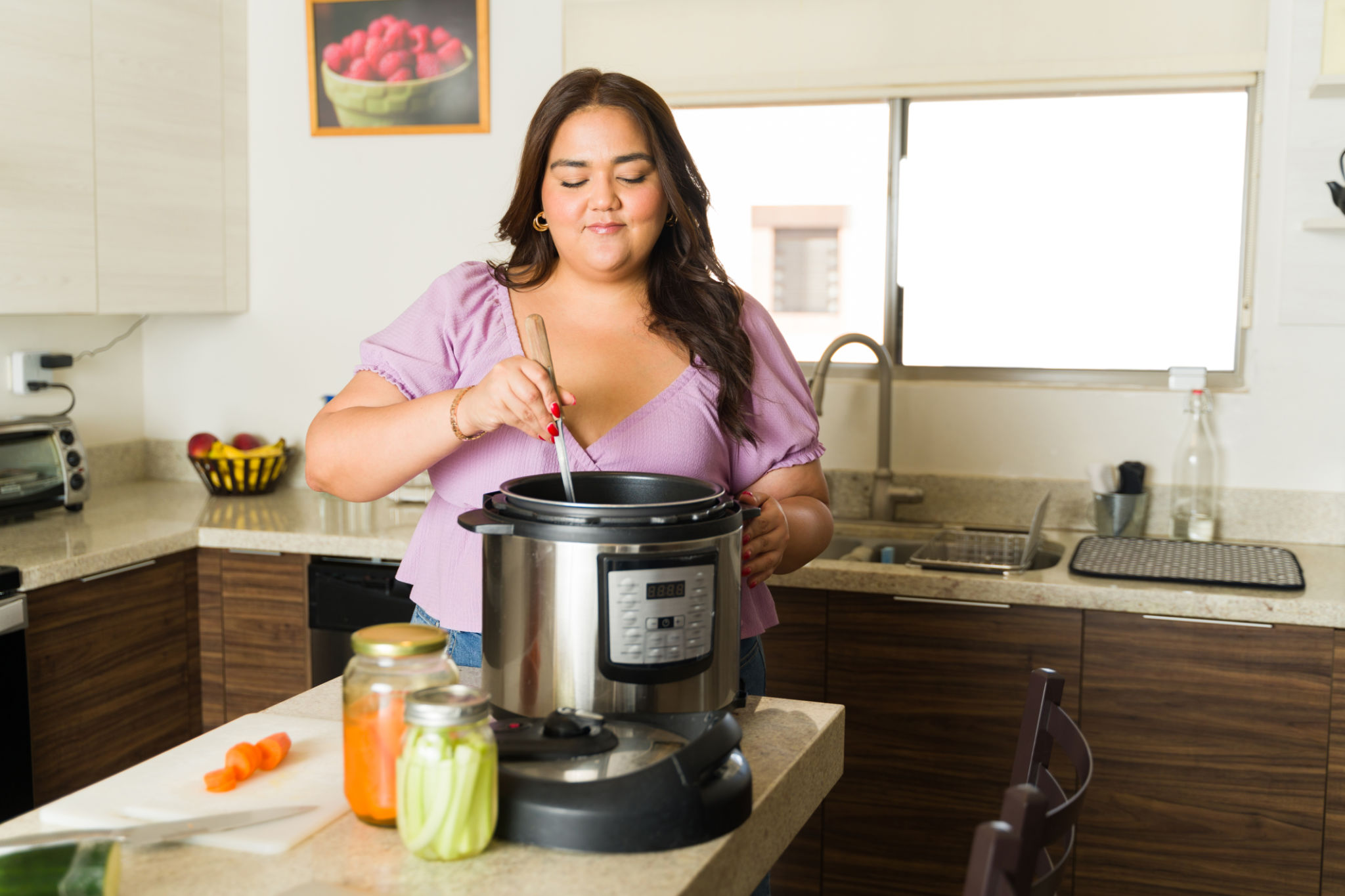 Happy woman cooking with the pressure cooker doing house chores Happy woman cooking with the pressure cooker doing house chores
