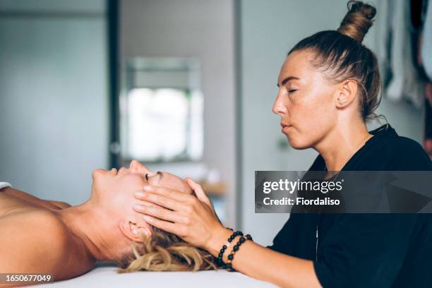 woman massage therapist doing manual therapy to patient - acupuncture stock-fotos und bilder