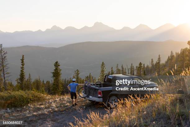 male mountain biker beside pick-up truck - pickup bildbanksfoton och bilder