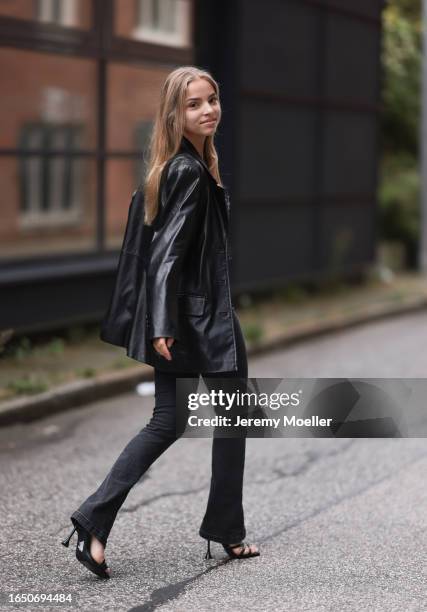 Patricia Lilith Richter seen wearing gold jewelry, black / grey denim buttoned corset top, matching black / grey denim long slit pants / jeans, black...