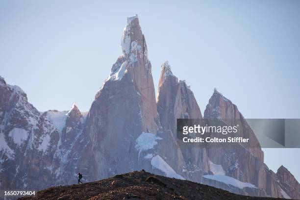 a hiker silhouetted against the massive peaks of cerro torre in los glaciares - patagonian andes stock pictures, royalty-free photos & images