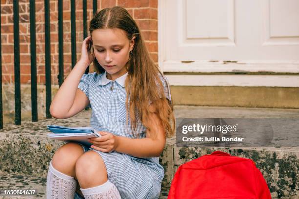 elementary school girl with notepad sitting on a school stairs - cute college girl stock pictures, royalty-free photos & images