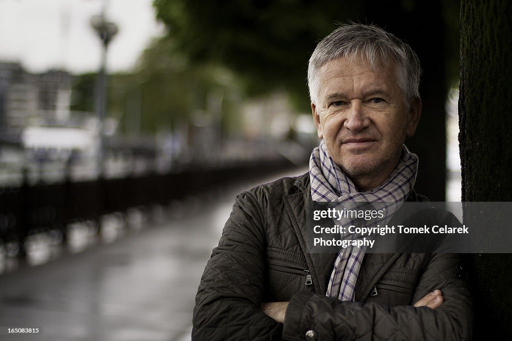 Portrait of man leaning against tree in Geneva.