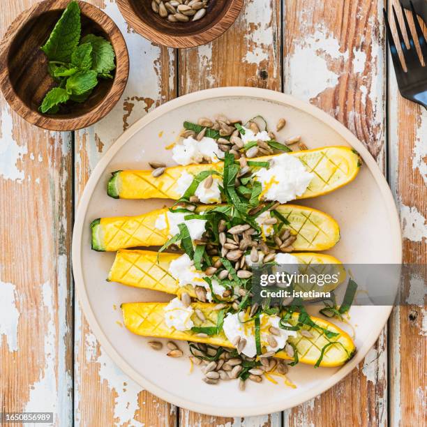 grilled yellow zucchini with ricotta cheese, sunflower seeds, lemon zest, and fresh mint - courgette stock pictures, royalty-free photos & images