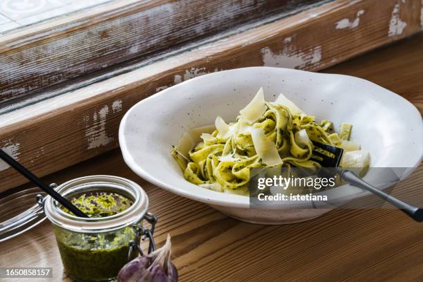 pasta with green pesto and parmesan, healthy vegetarian dish - parmesan stock-fotos und bilder