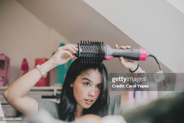 young woman combing hair - liscio foto e immagini stock