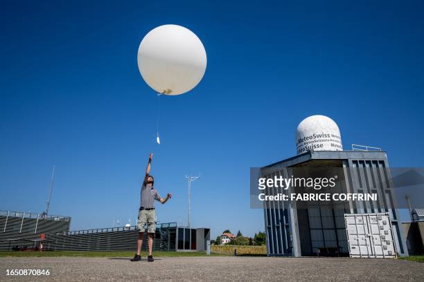 Picture taken on September 7, 2023 shows meteorologist Laurent Moullet launching a weather balloon measuring the zero degree isotherm at MeteoSwiss...