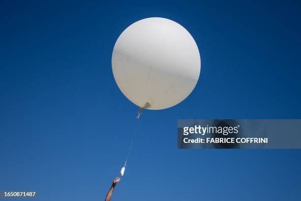 Picture taken on September 7, 2023 shows meteorologist Laurent Moullet launching a weather balloon measuring the zero degree isotherm at MeteoSwiss...