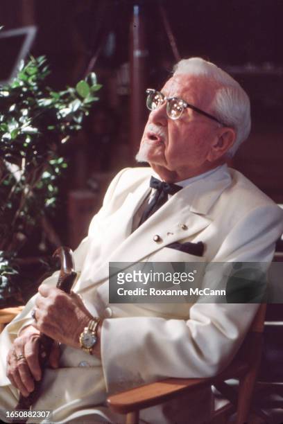 Colonel Harland David Sanders who founded the fast food restaurant chain Kentucky Fried Chicken and who is wearing a white suit, a Kentucky Colonel...