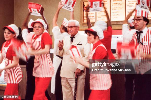 Colonel Harland David Sanders who founded the fast food restaurant chain Kentucky Fried Chicken and who is wearing a white suit, a Kentucky Colonel...